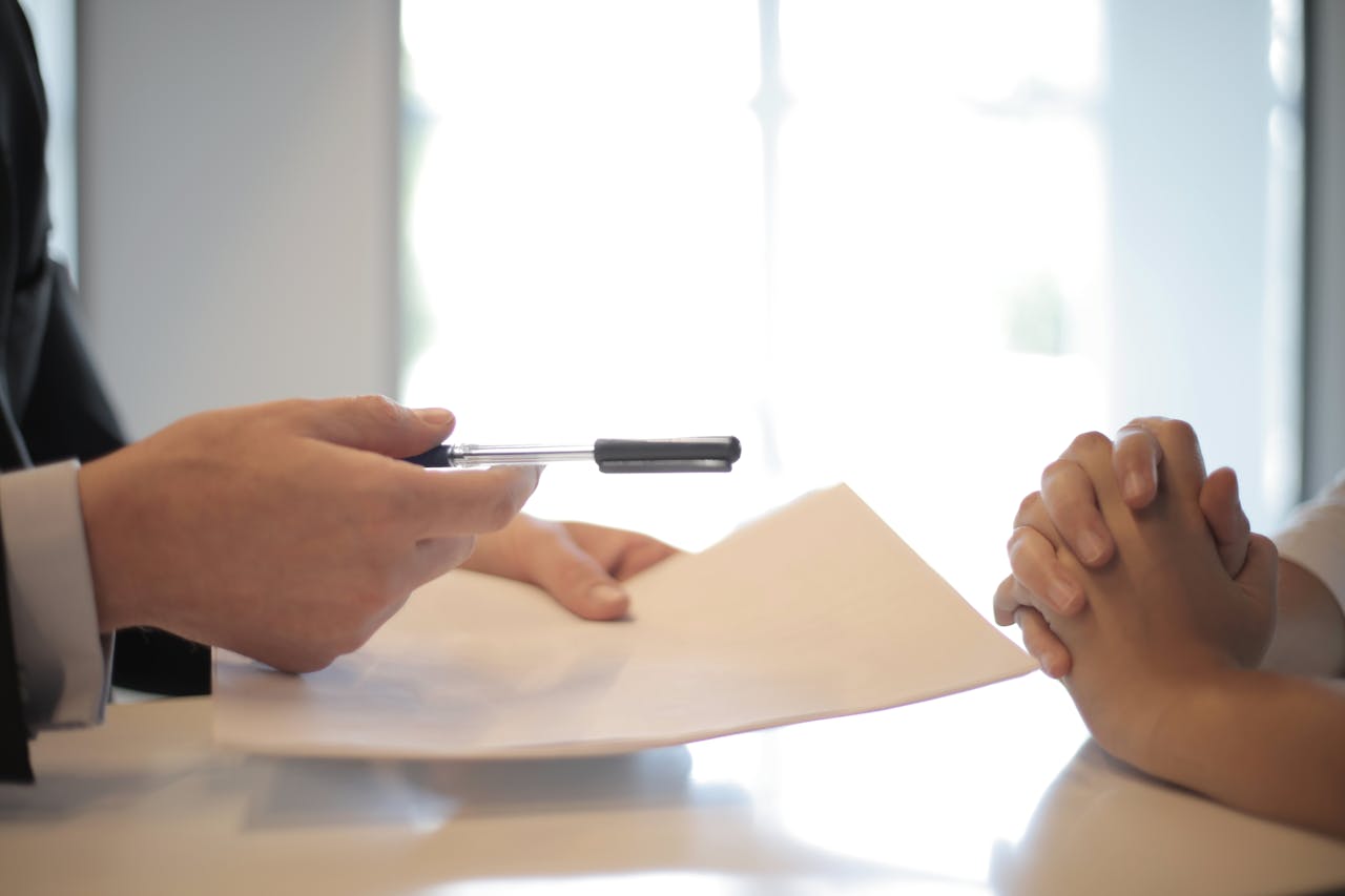 services-01 Close-up of a contract signing with hands over documents. Professional business interaction.