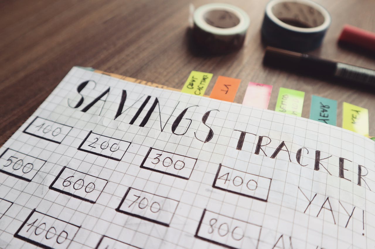 about-us Close-up of a handmade savings tracker with colored tabs on a wooden table, ideal for financial planning visuals.